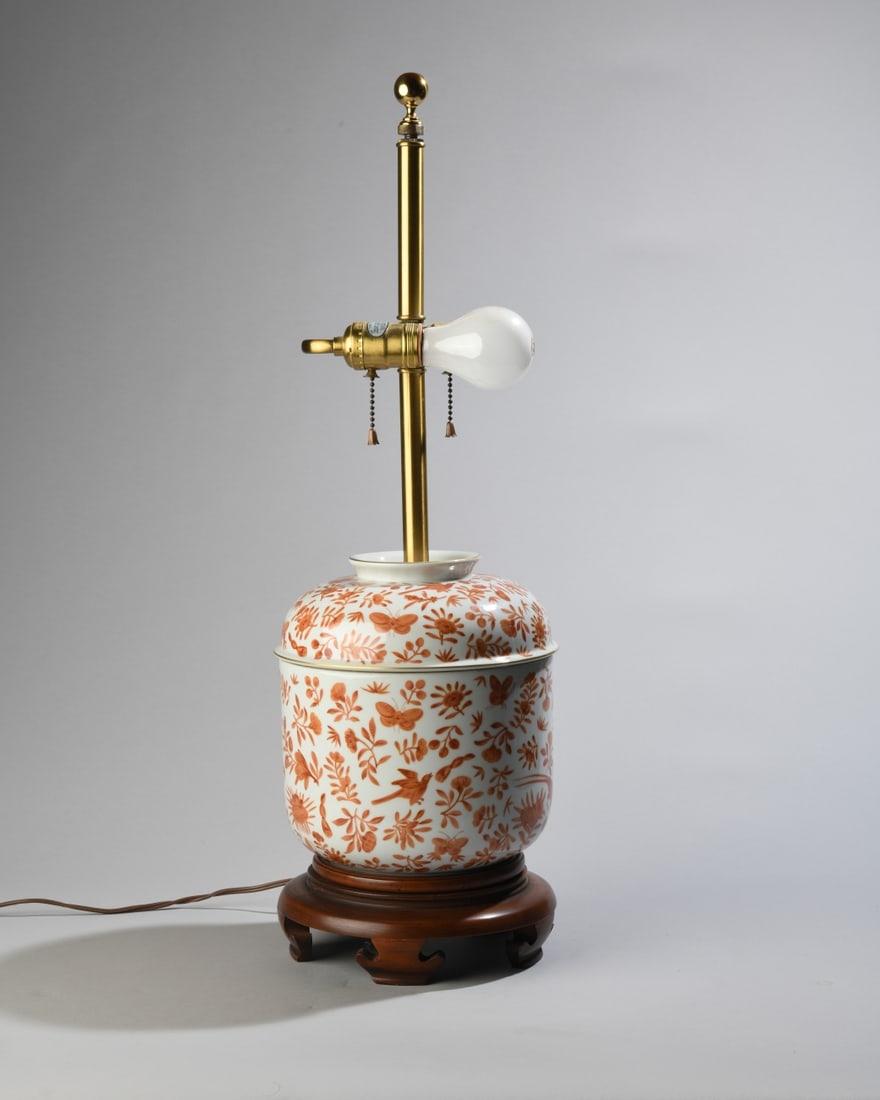 Norman Perry Chinoiserie Ginger Jar Table Lamp: Decorated throughout with iron-red floral, foliate, bird, and butterfly motifs, mounted on a wooden base with brass standard, ball finial, and double pull-chain sockets. Powers on. H: approx. 25".