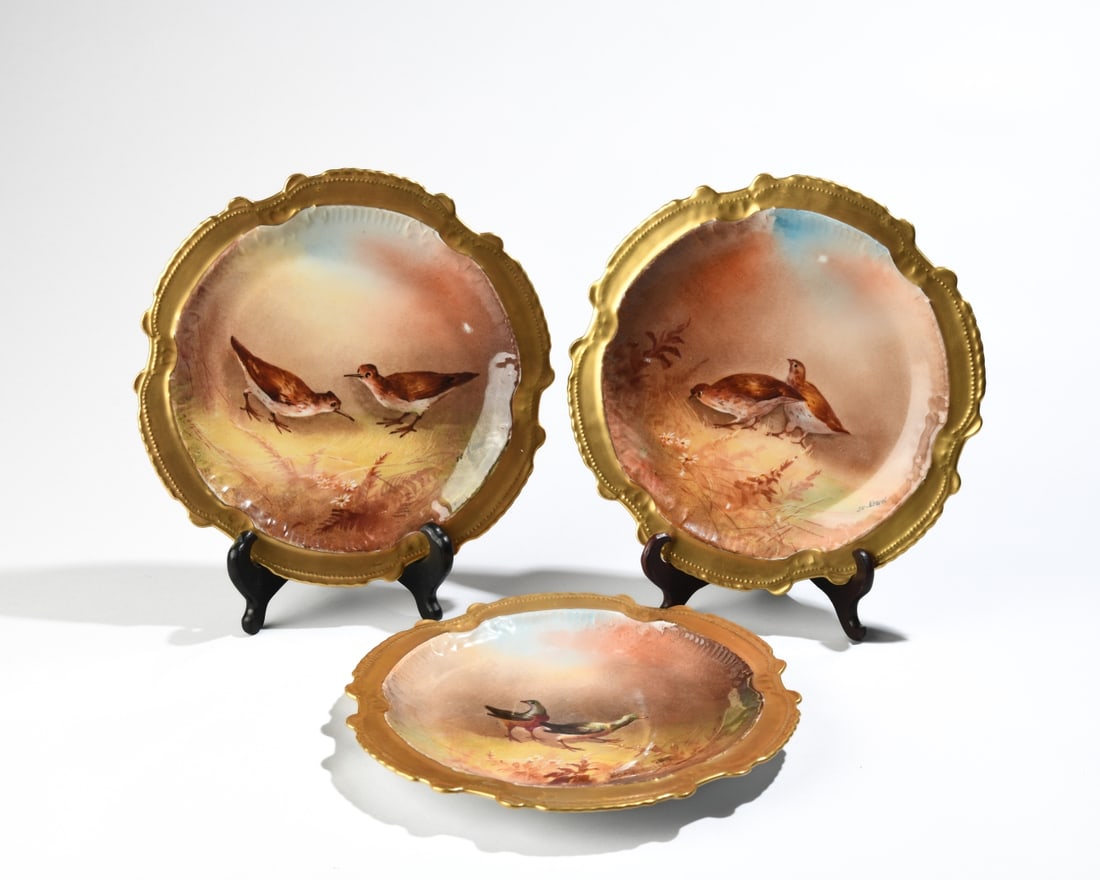 3 pc. Limoges Hand-Painted Plates: Three porcelain plates with gilt scalloped borders, each hand-painted with a different pair of birds. Artist signature De Nerval signed to front, with Limoges marks to underside. Some minor paint