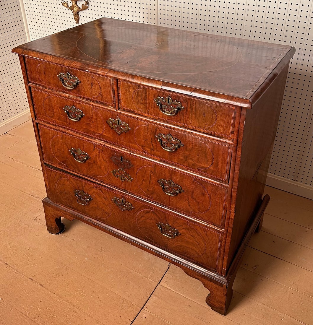 Mid 18th C. English Walnut Veneer Chest of Drawers: With oak and pine secondary woods, top features a large oval veneered panel within stringing, two short over three long dovetailed drawers each with veneered fronts, shaped bracket feet. Damage and lo