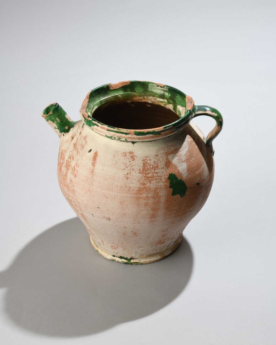 Antique French Green Glazed Pottery Jug: French earthenware jug with globular body, single strap handle, and pouring spout. Likely late 19th to early 20th century. Surface wear, glaze losses, and rim chips consistent with age and use.