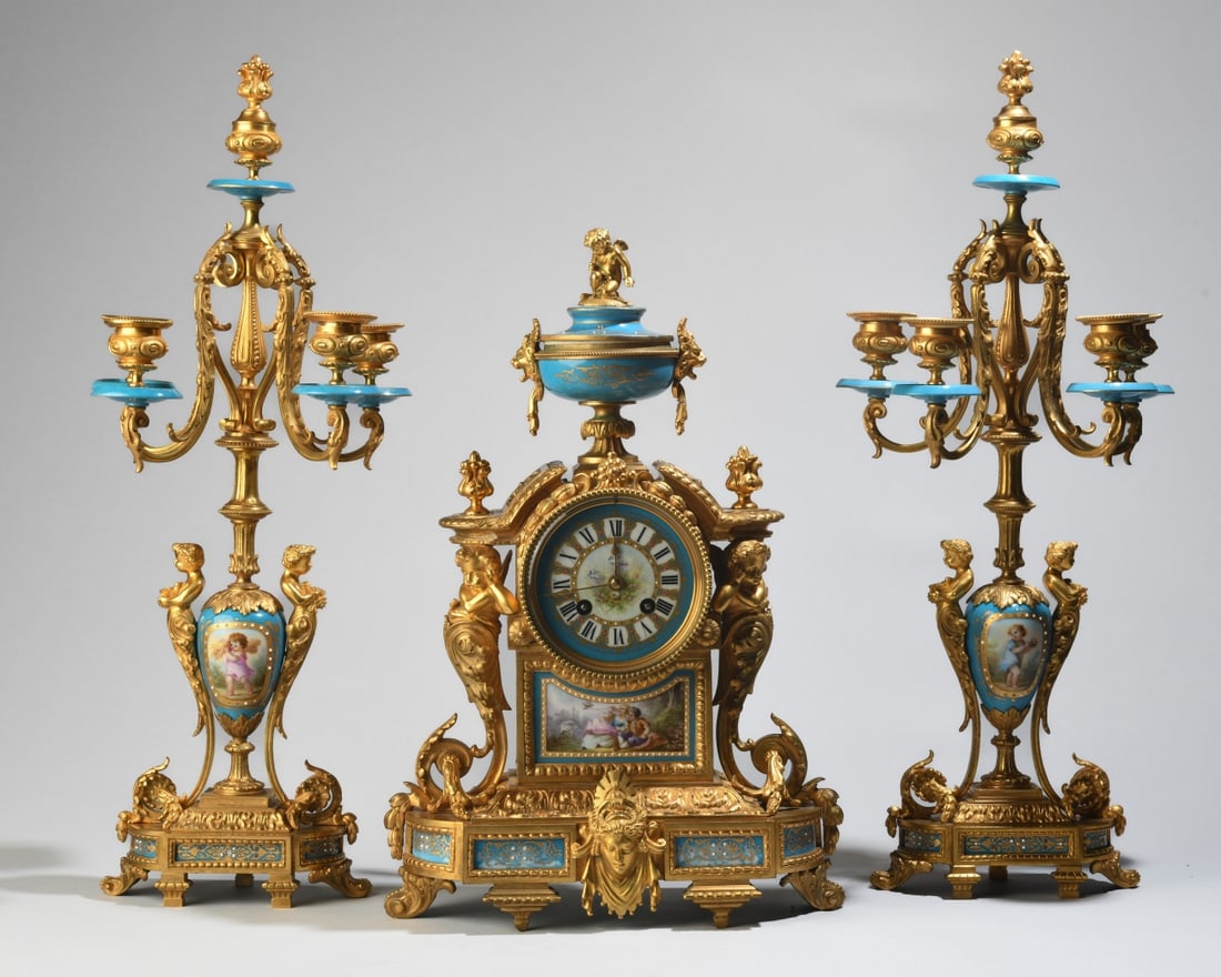Set of French Sèvres-Style & Champlevé Garniture: A fine French late 19th century three-piece Napoleon III clock garniture. Comprising a mantel clock and a pair of matching five-light candelabra, all featuring bleu céleste porcelain bodies