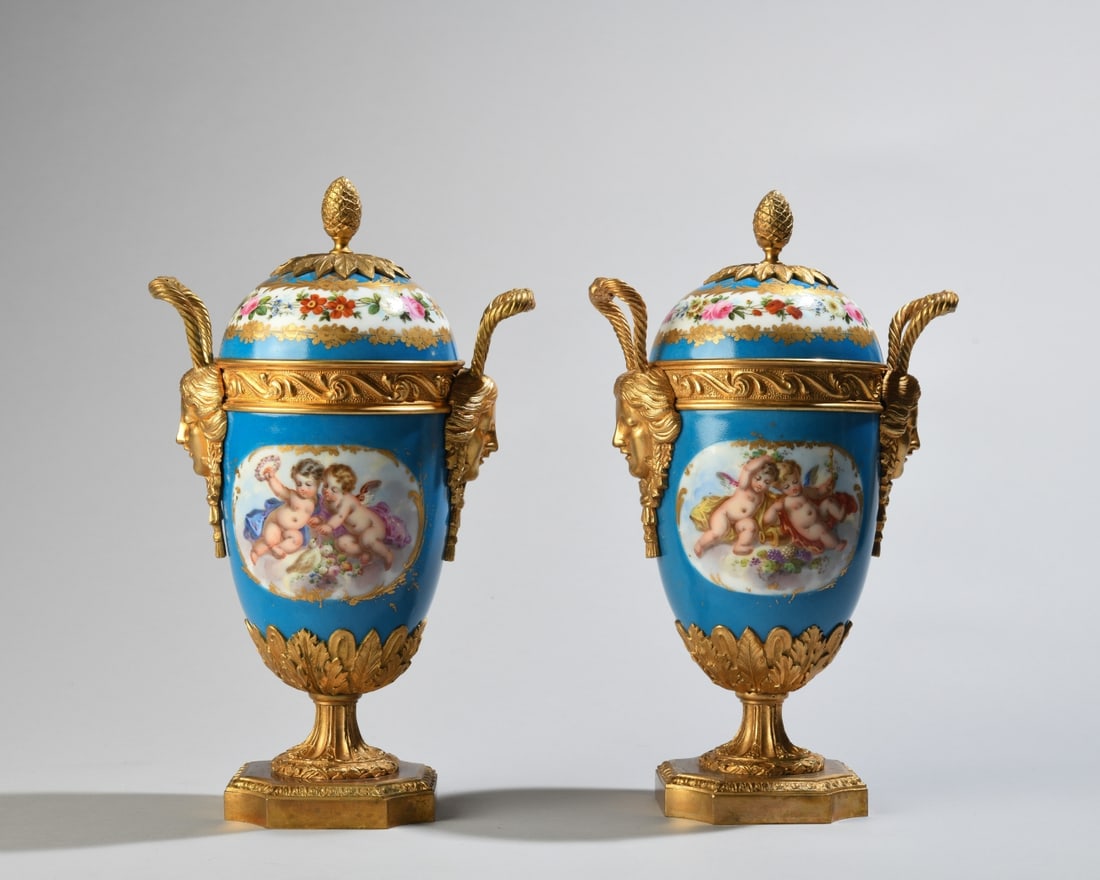 Pair of French Sevres-Style Porcelain Urns: Pair of French porcelain covered urns, attributed to Samson & Cie., Paris, late 19th century, decorated in the Sèvres taste with bleu céleste grounds, hand-painted putti and floral reserves within