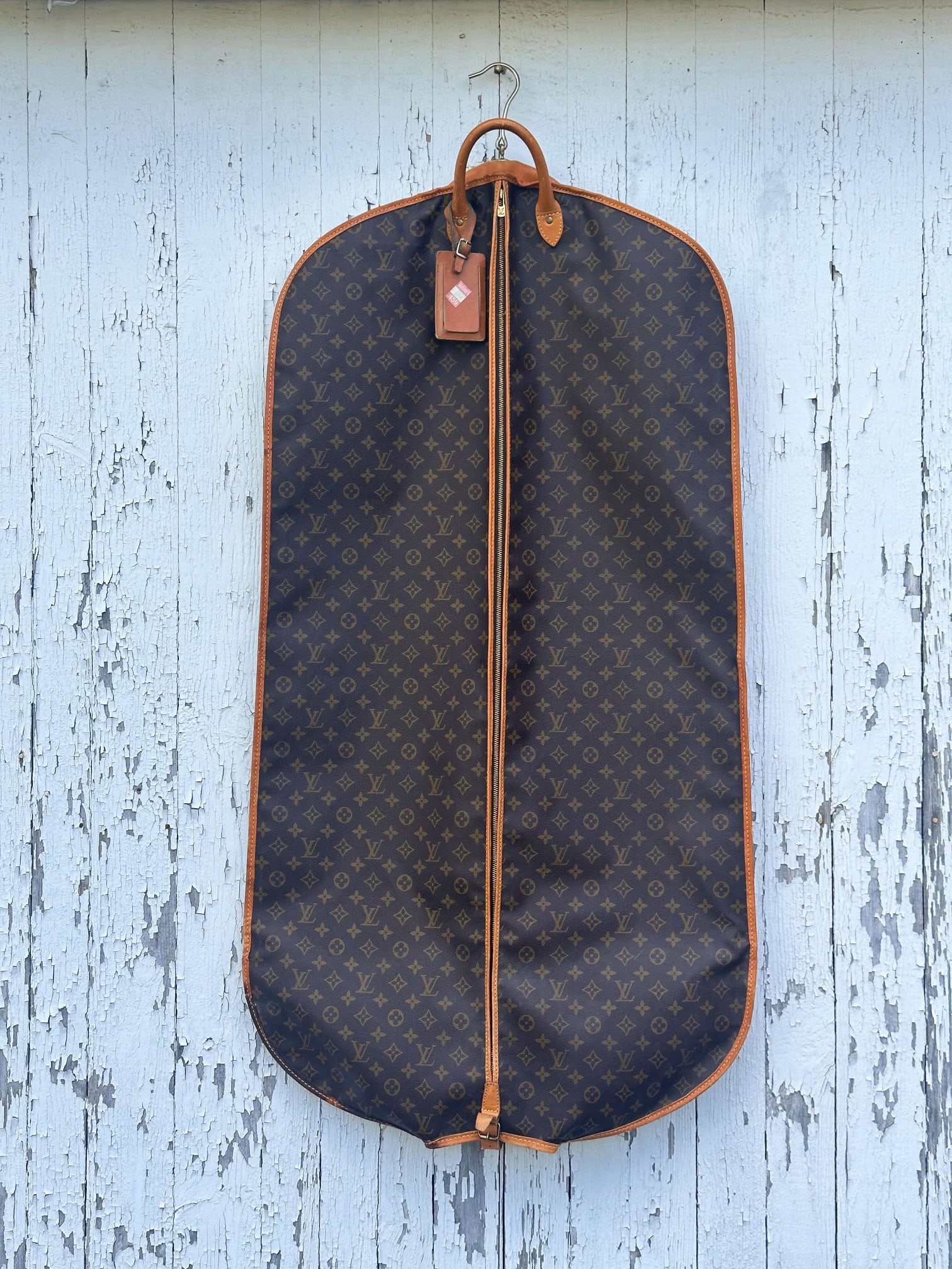 Vintage Louis Vuitton Garment Bag: Full length zippered garment bag by Louis Vuitton with monograms, rolled leather handles, leather trim and brown interior. Some wear and discoloration to trim near bottom / in as-found condition. Appr