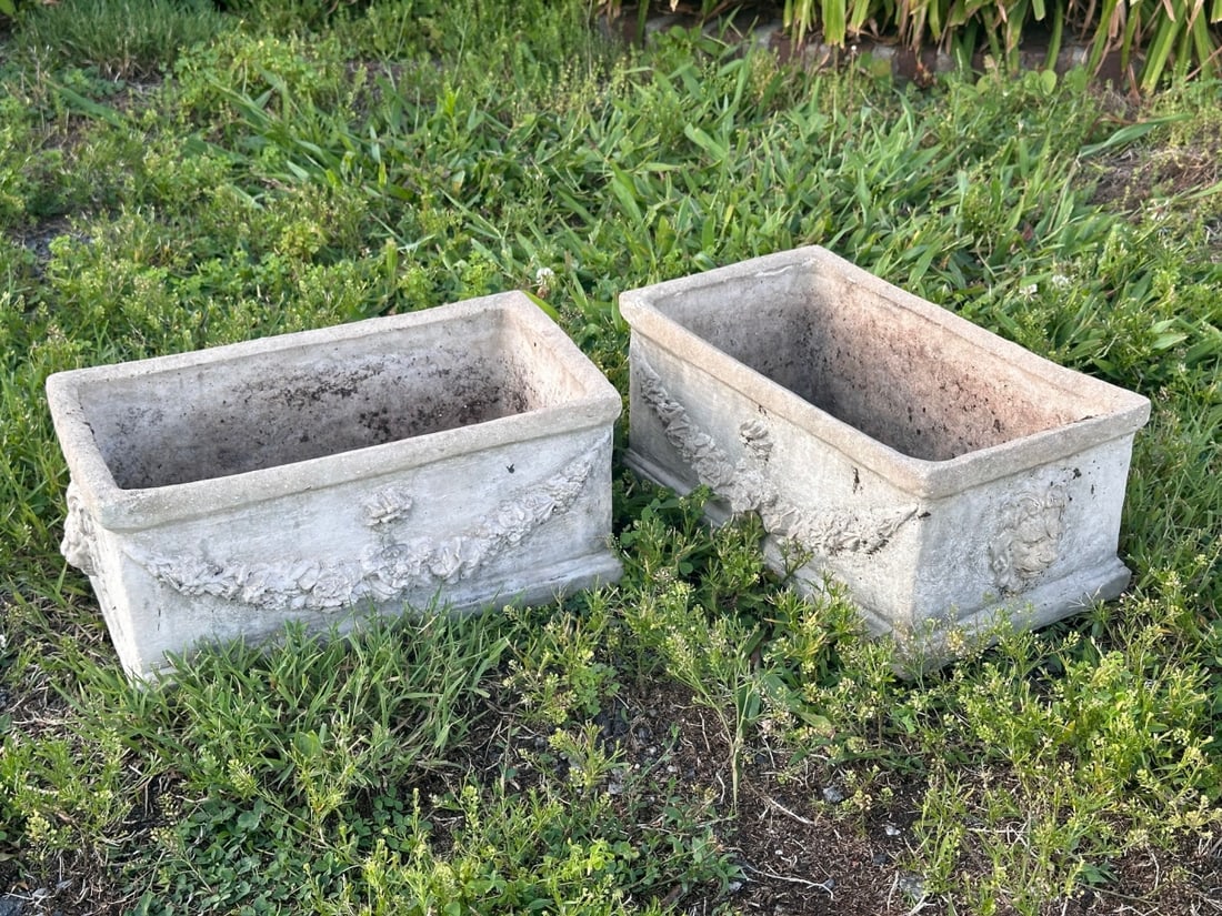 Pair of Cast Stone Garden Planters: With Lion mask terminals and floral swag decoration, some weathering. Approx. 7 1/4" x 16 1/4" x 9". VHC 390 Our primary recommendation is to arrange shipping yourself using Blue Ridge Pack & Ship. Mo