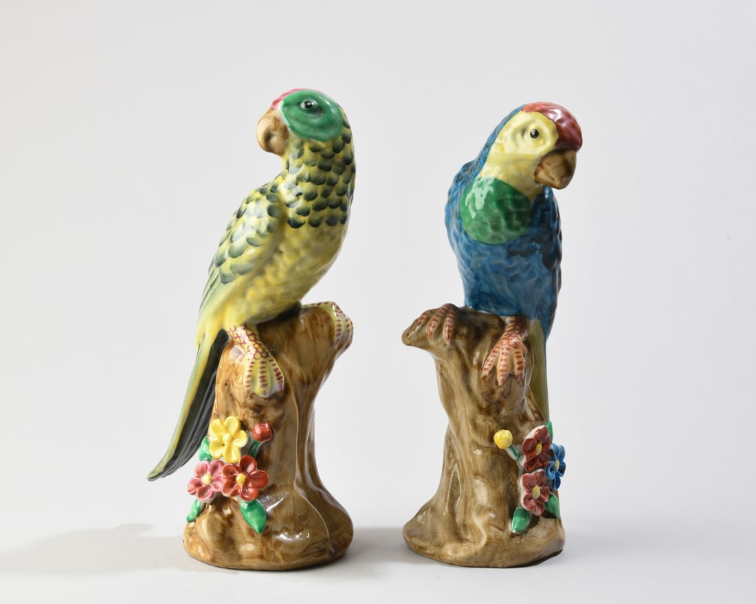 Pair of Decorative Porcelain Parrot Figures: Finely modeled and hand-painted porcelain parrots, one with blue wings and one with yellow, polychrome floral decorated tree stump bases. No visible maker's marks. One with small glaze flake to back, 