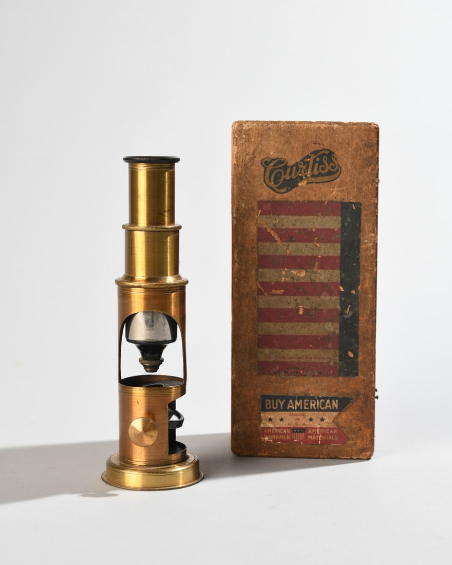 Antique French Brass Drum Microscope: Small French brass drum microscope, early 20th century, marked "Made in France." Monocular brass body with lower mirror, wooden case with Curtiss and Buy American decals. Untested, completeness