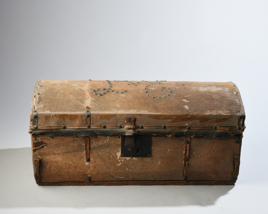 19th C. Hide Covered Document Box: Interior lined with Philadelphia newspaper dated March 22, 1827. Exterior features hide-covered domed lid with nailhead initials and trim, leather-covered sides, and iron lock plate and handles. Signi
