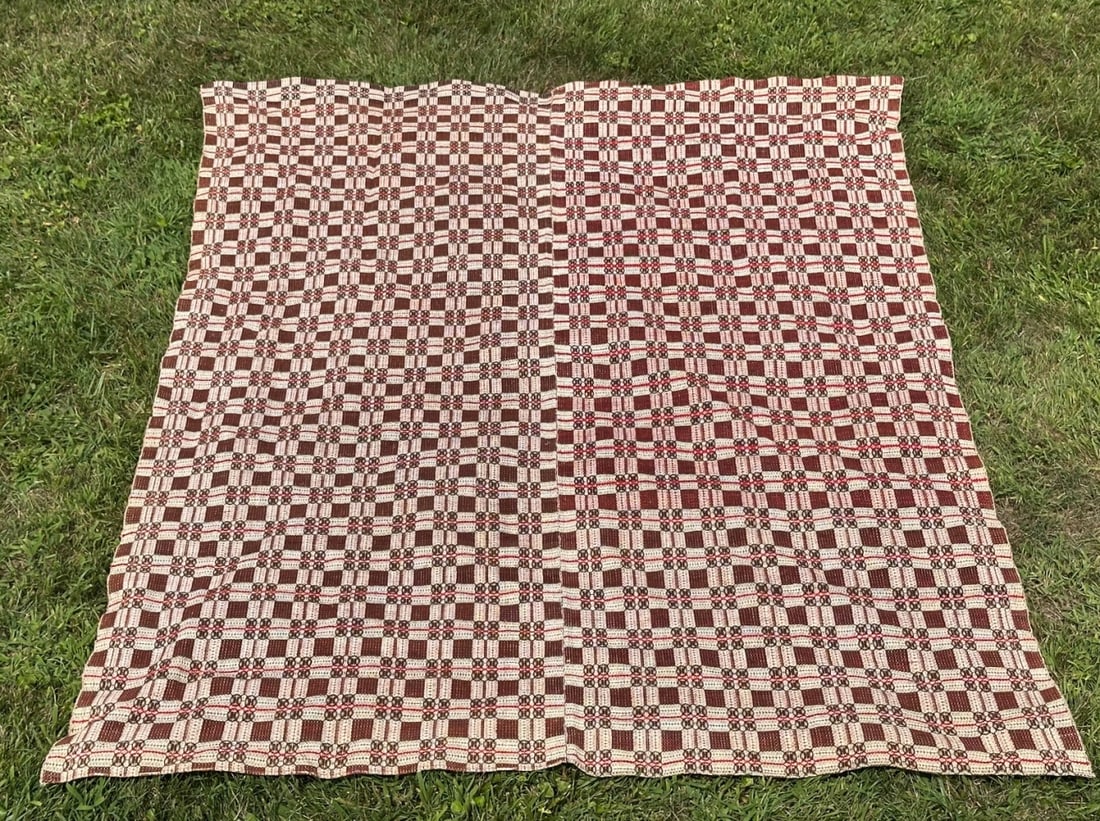 19th C. American Overshot Coverlet: Wool and cotton overshot woven coverlet in a geometric optical pattern, the field in dark burgundy and natural white with red accent stripes. In as-found condition. Approx. 87" x 68". Provenance: the 
