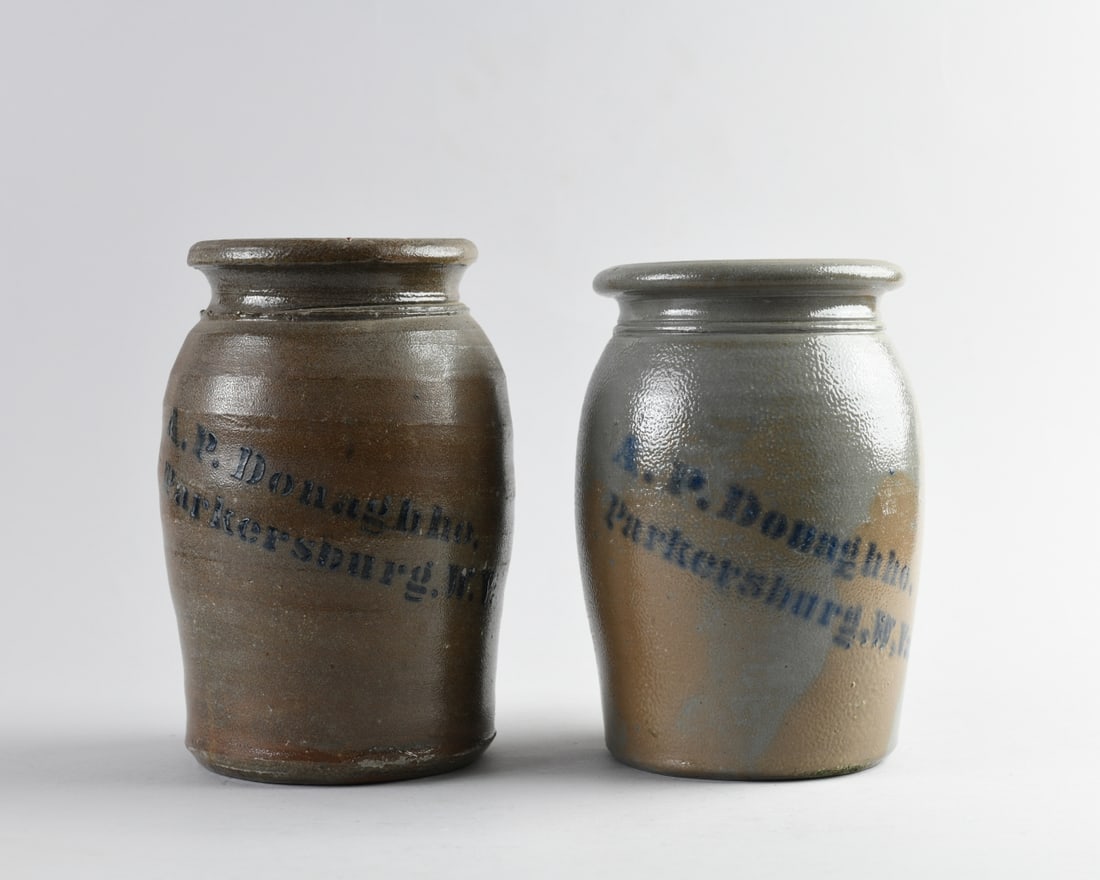 Two A.P. Donaghho Stoneware Canning Jars: Two stoneware canning jars by A.P. Donaghho with cobalt stenciled mark reading "A.P. Donaghho / Parkersburg, W.Va.". Likely circa 1880. Minor chips. Largest, H: approx. 8 1/2", Dia: approx. 5". Our