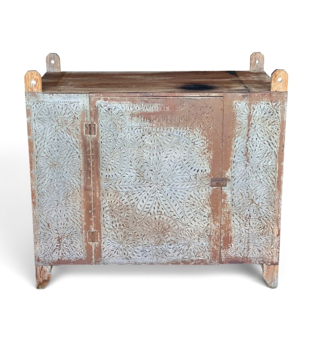 Punched Tin & Pine Pie Safe: Single door pine pie safe, the front, sides, and door panel clad in punched tin with a radiating floral / starburst pattern. The side panels punched with the name 'J.L. Long' within a rectangular cart
