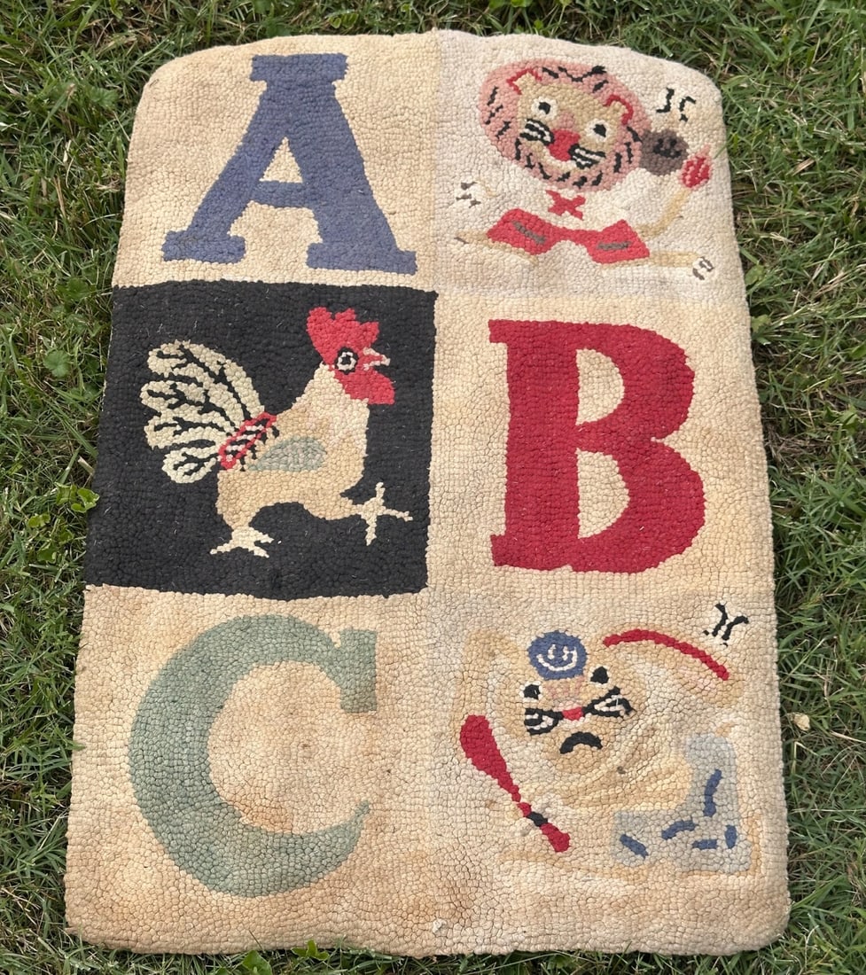 Folk Art Alphabet Theme Hooked Rug: Hand hooked wool rug with alphabet block design incorporating figural motifs including a rooster and playful characters. In as-found condition. Approx. 36" x 23". Provenance: the estate of John Long,