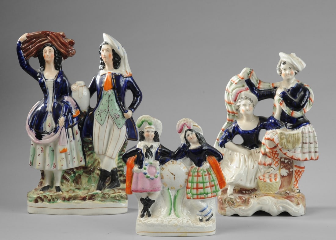 Three 19th C. Staffordshire Pottery Figures: Group of three English Staffordshire earthenware figures, mid to late 19th century. Includes a pair of women flanking a clock face, a man and woman in rustic dress, and a couple with a basket. All