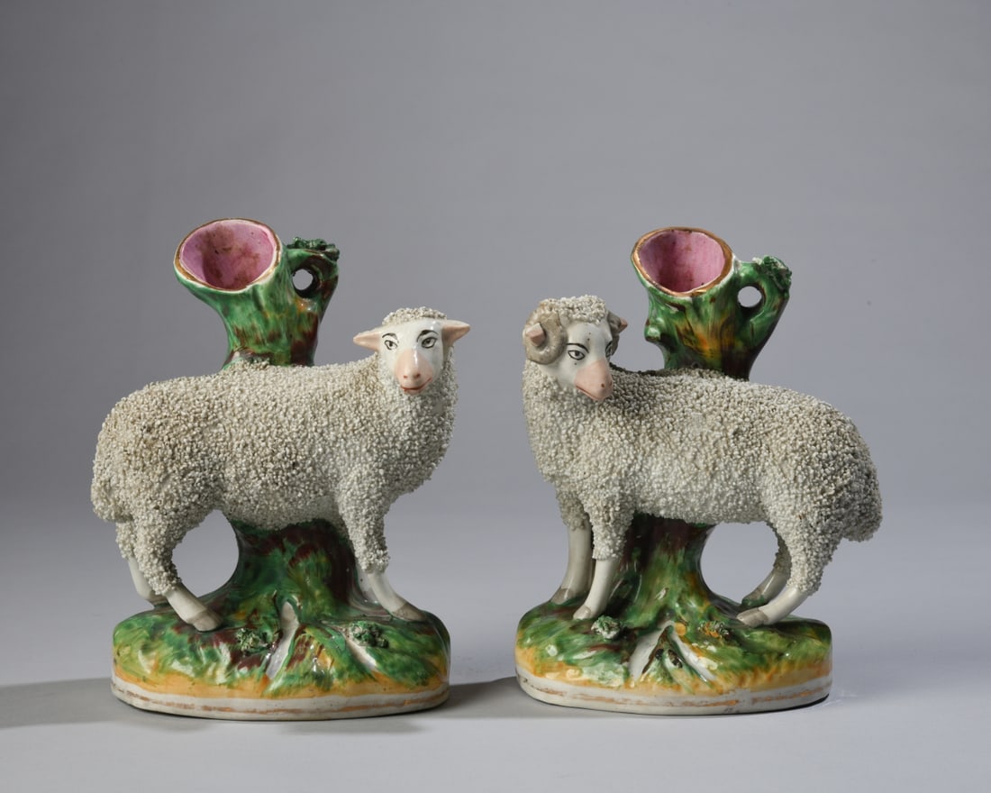 Pair of Staffordshire Pottery Sheep Spill Vases: English, 19th century, each modeled as a standing sheep with textured fleece before a tree trunk spill vase, on naturalistic bases. Minor scattered chips and wear. Approx. 7" x 5" x 3". Our primary re