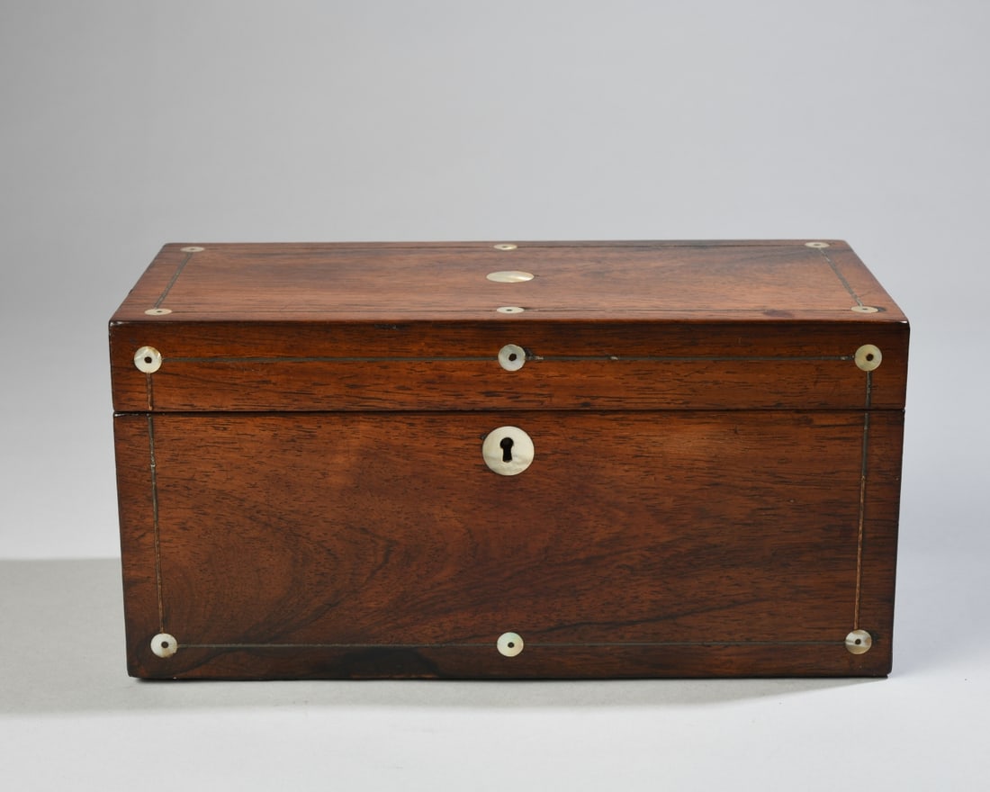 A Regency / William IV Inlaid Rosewood Tea Caddy: A Regency / William IV period English rosewood tea caddy, inlaid with mother of pearl roundels and pewter or brass stringing. The hinged lid opens to a re-lined three compartment interior. Dimensions