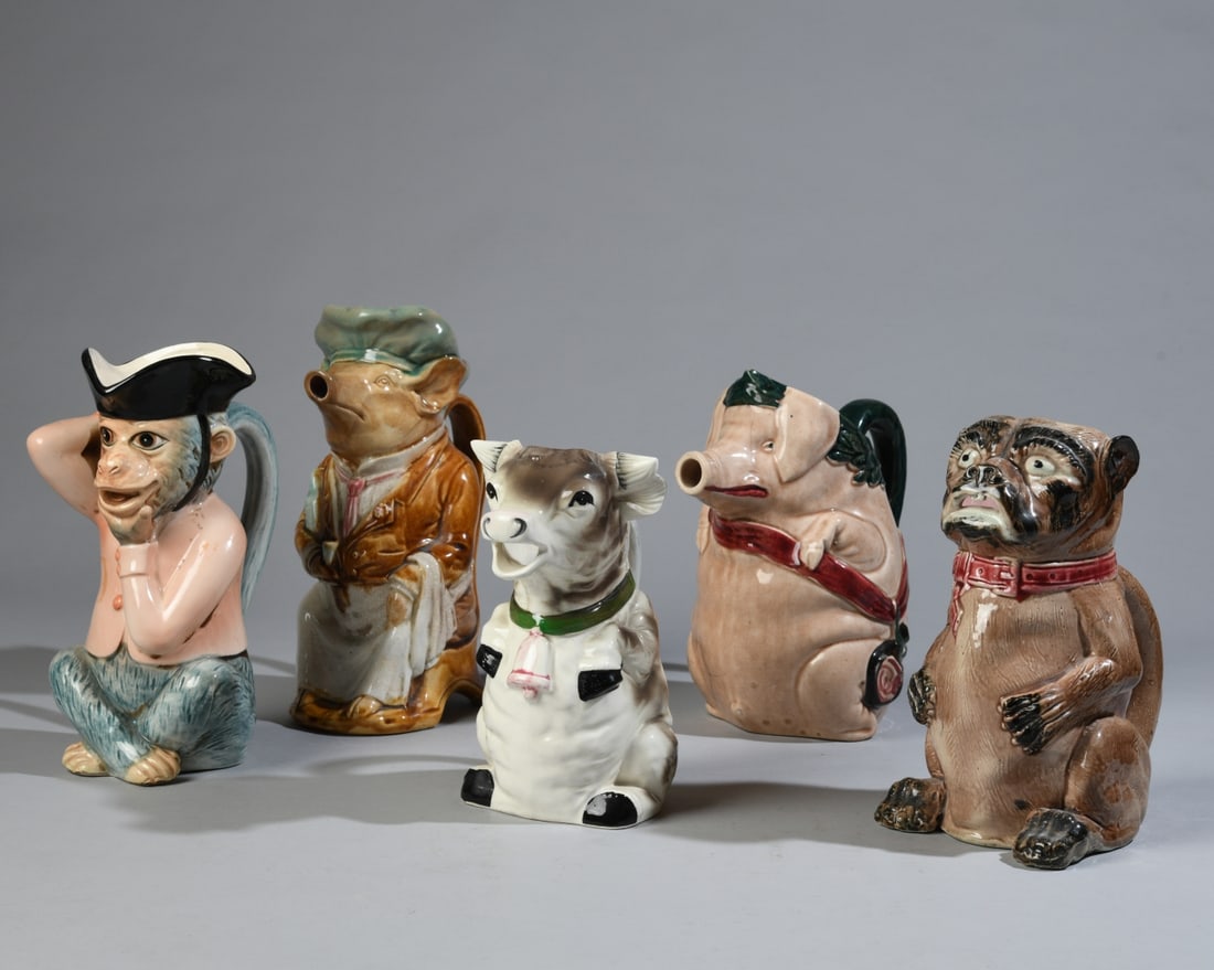 Five Continental Character Jugs: Group of five late 19th/early 20th century Continental glazed earthenware character and novelty jugs, including monkey, dog and pig forms. Polychrome molded decoration; several with impressed or