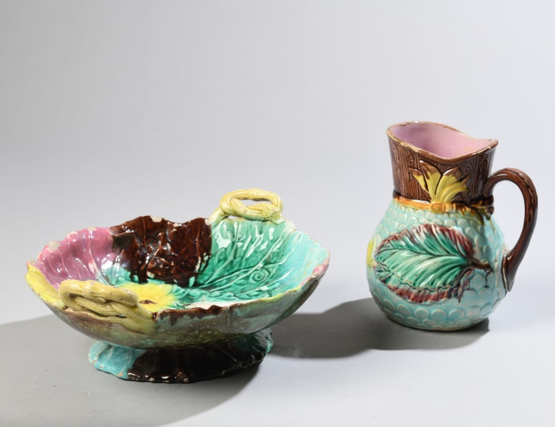 Two Majolica Pottery Pieces: Late 19th/early 20th century, comprising a molded pitcher decorated with large leaves in turquoise, green, yellow and brown glazes, and a two-handled floral and foliate bowl in polychrome glazes.
