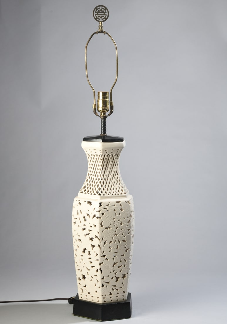 Reticulated Blanc de Chine Table Lamp: Mid-20th century, on wooden base, with interior bulb to illuminate pierced design. In working condition. Dimensions: approx. 35" H x 9" dia. Our primary recommendation is to arrange shipping yourself 