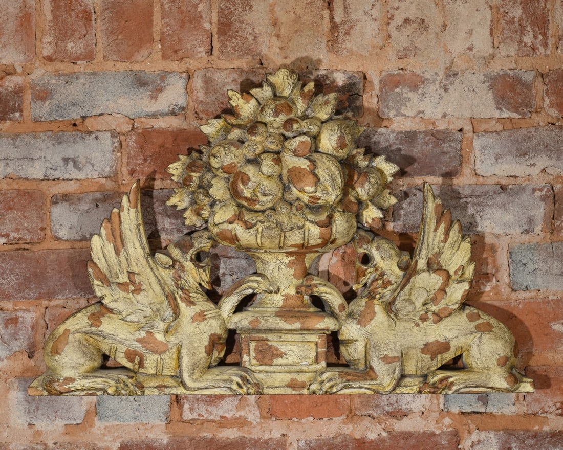Griffin & Fruit Urn Architectural Wall Pediment: 20th / 21st century composite architectural wall pediment featuring two flanked winged griffins supporting a central urn with overflowing fruit. Dimensions approx. 24" x 16 1/4". Our primary