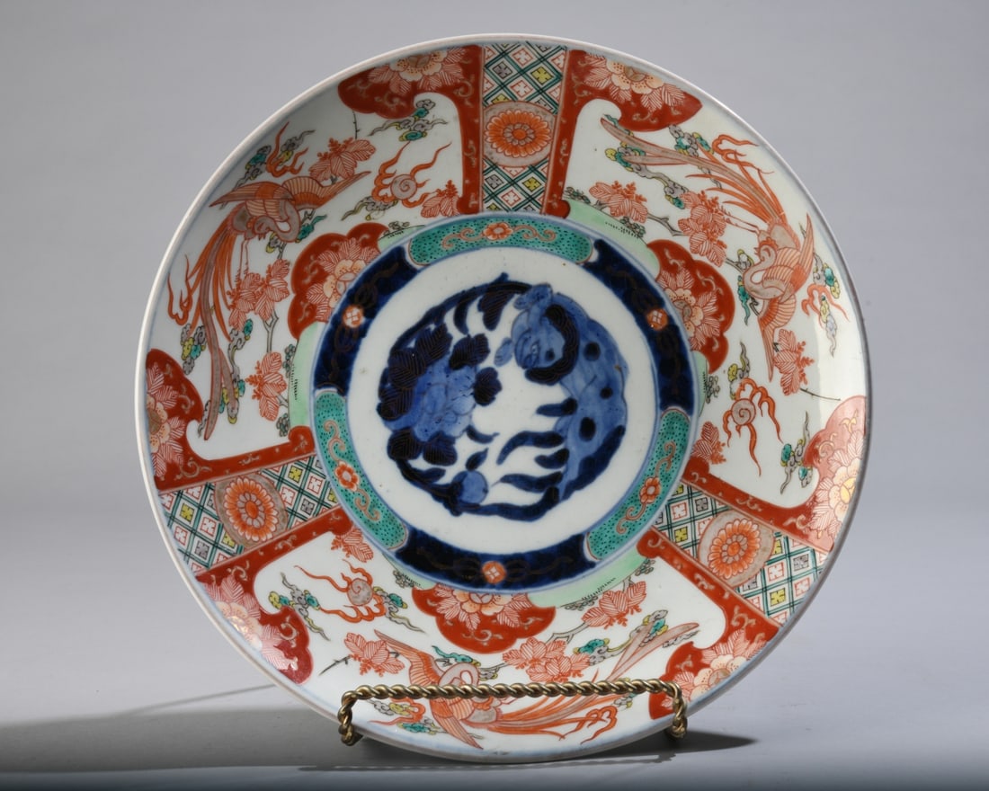 Antique Japanese Imari Phoenix Charger: Likely Meiji period, late 19th century, with central lion and peony medallion surrounded by phoenixes, floral motifs, and geometric panels. Underside with floral decoration. No chips, cracks or