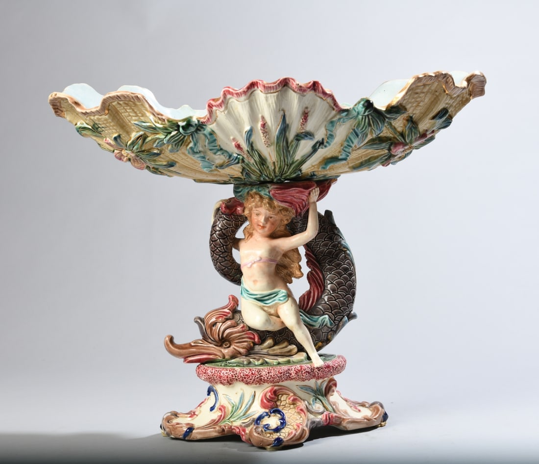 Eichwald Majolica Centerpiece with Figural Dolphin: Early 20th century, impressed "Eichwald 4159" to underside, two part construction connected by central brass bolt. Shell form bowl supported by base with sea nymph and dolphin figures. Some glaze