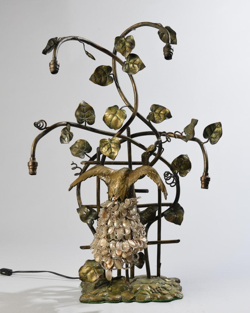 Art Deco Peacock and Ivy Lamp: An Art Deco style 4-light table lamp featuring a patinated bronze finish. Depicts a peacock perched against a garden trellis surrounded by climbing ivy leaves. The tail is woven with mother-of-pearl a