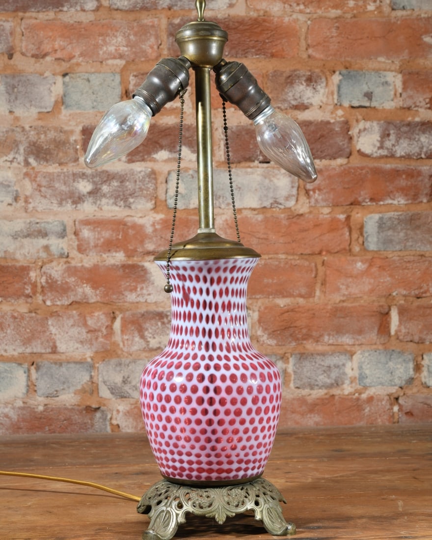 Cranberry Glass Vase Table Lamp: Baluster vase in cranberry glass, fitted as a table lamp on a pierced brass foot. Dimensions approx. 25" x 8" x 8". Our primary recommendation is to arrange shipping yourself using Blue Ridge Pack & S