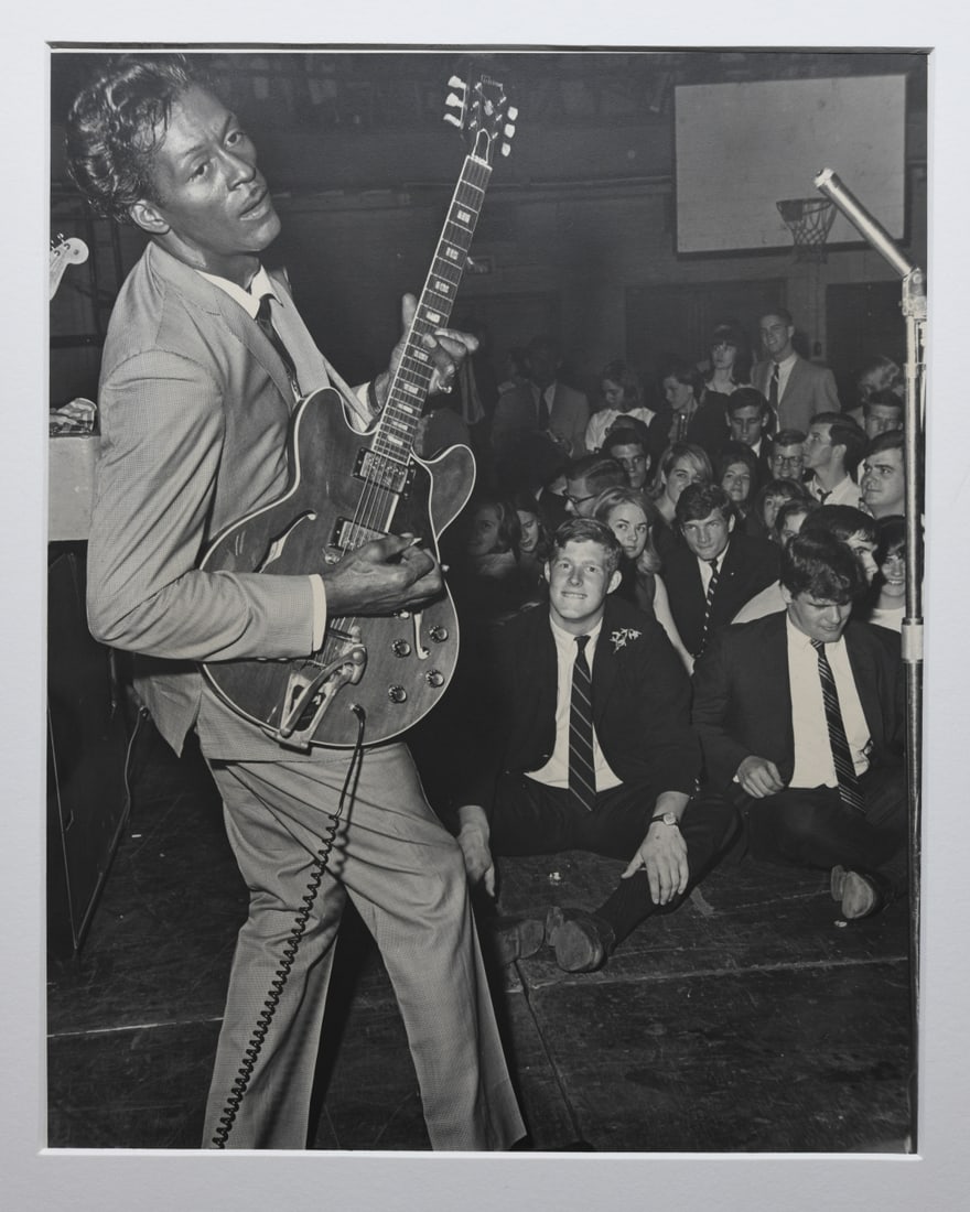 Ed Roseberry (American, 1925 - 2022) Chuck Berry: Chuck Berry performing at Memorial Gymnasium, University of Virginia, Charlottesville, April 1965. Mounted to matting, pencil signed and dated to inner mat. Approx. 14" x 11". Matting approx. 22" x