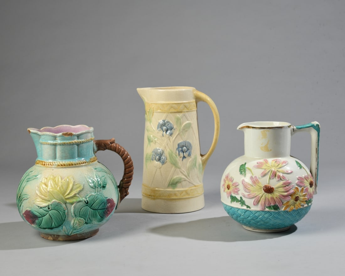 Three Floral Majolica Pitchers: Late 19th/early 20th century, all with floral decoration, unmarked. Crazing, staining, glaze losses, and rim chips. Largest dimensions: approx. 9 1/2" x 8" x 7". Our primary recommendation is to