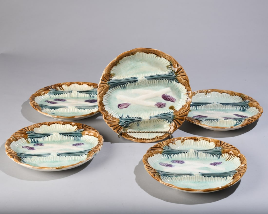 Five Antique Majolica Asparagus Plates: Late 19th / early 20th century, likely English or Continental, each naturalistically molded with asparagus spears, leafy divisions, and scalloped borders. Overall crazing, scattered surface wear,