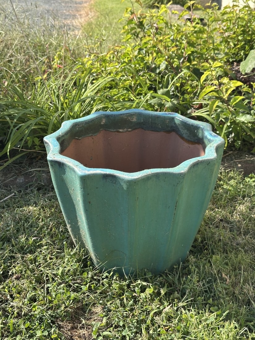 Glazed Pottery Jardiniere: Large pottery jardiniere with scalloped rim, covered in a mottled turquoise green glaze, the interior unglazed. Surface wear, abrasions and weathering from outdoor use. Dimensions apprx. 15 1/2" x 20 