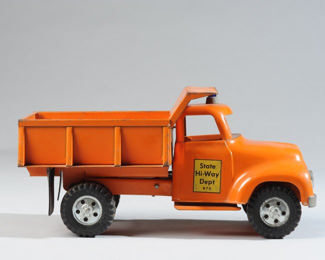 1950s Tonka Rear Dump Truck: State Hi-Way Dept 975 Tonka dump truck with original headlights, top light, mud flaps, wheels, great unrestored condition. Some play wear to surfaces. Length approx. 13".