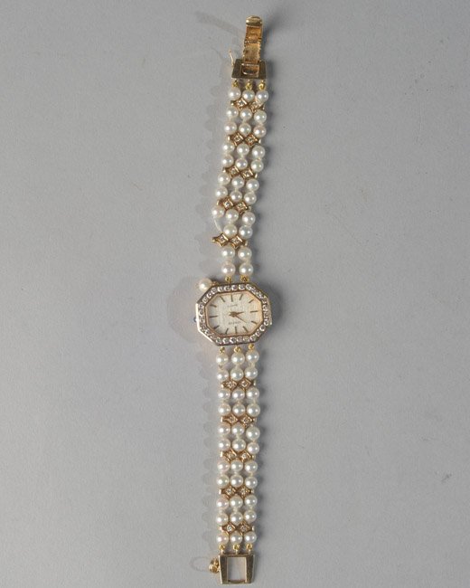 Lady's Geneve Wrist Watch: Case marked 14k. Small diamonds surrounding face, pearl and gold band, missing two pearls.