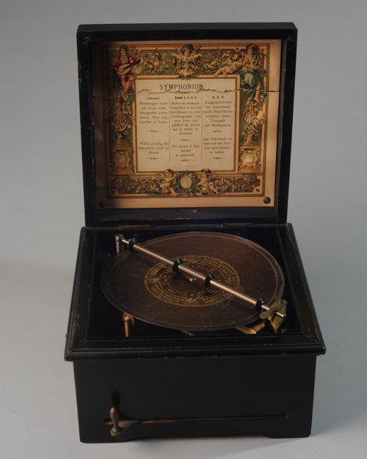 Continental Symphonion Music Box: Paper label in English, French and German to underside of lid: "Patented. Steeltongue musical boxes with changeable music sheets. Play any number of times. While playing the instrument must be closed.