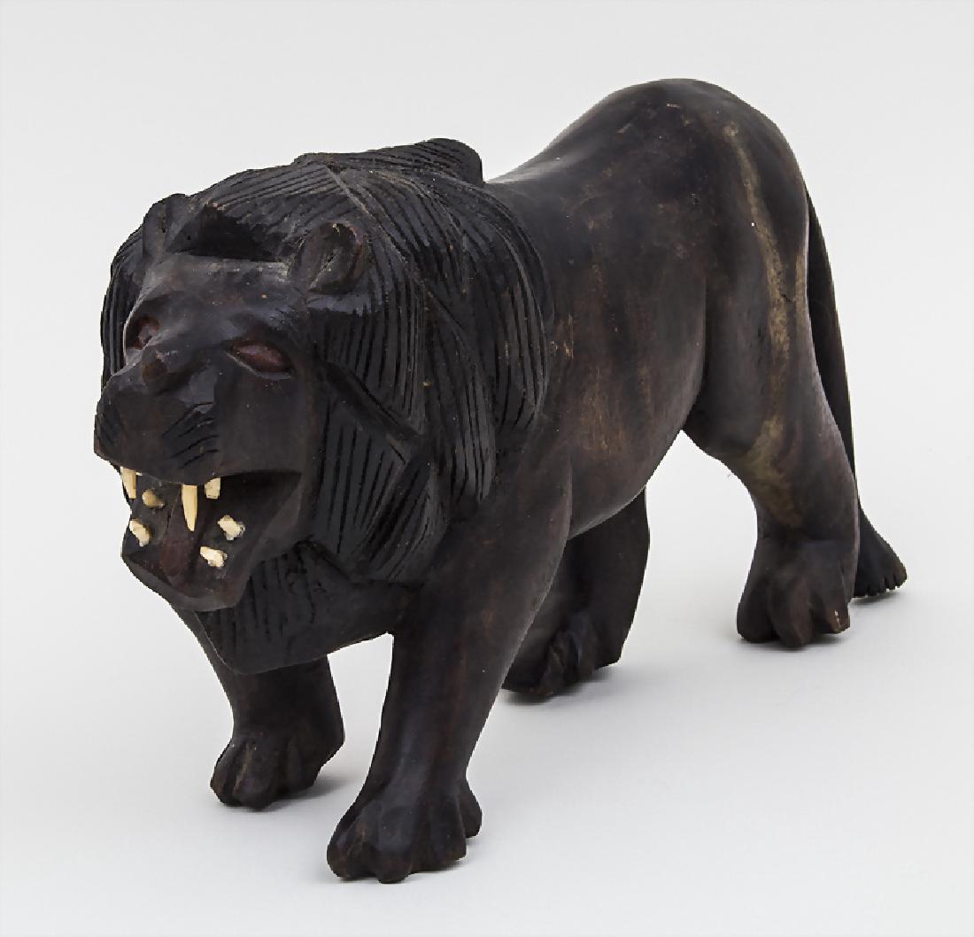 Löwenskulptur / A lion sculpture, 20. Jh. Material:: Löwenskulptur / A lion sculpture, 20. Jh. Material: Holz geschnitzt und patiniert, Zähne aus Knochen, Maße: H. 18 cm, L. 32 cm, Zustand: gut + Material: wood, carved and patinated, teeth made of bo