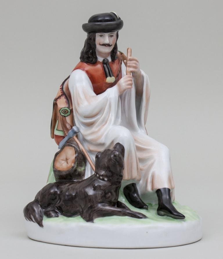 Hirte mit Hund/Herdsman With Dog, Zsolnay, Pecs/Ungarn,: Hirte mit Hund/Herdsman With Dog, Zsolnay, Pecs/Ungarn, 20. Jh. auf rundem Sockel sitzender Mann in ungarischer Tracht, eine Flöte in der Hand haltend und von seinem liegenden Hund begleitet. Porzell
