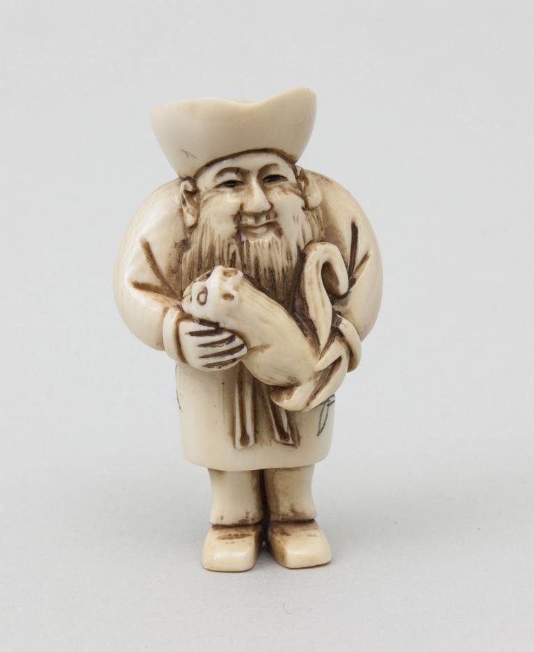 Mann mit Ratte/Man With Rat, Netsuke, Japan, um 1900: Mann mit Ratte/Man With Rat, Netsuke, Japan, um 1900 Elfenbein. Vollplastische Schnitzerei eines stehenden Mannes, eine Ratte in seinen Händen haltend. Kleidung des Mannes mit stilisiertem Floraldeko