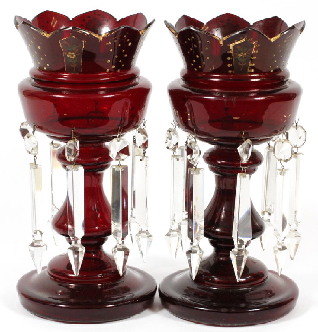 BOHEMIAN RED GLASS LUSTERS PAIR: BOHEMIAN RED GLASS LUSTERS, PAIR, H 13", DIA 6":A pair of Bohemian red glass lusters of chalice form tipped with pointed rims and having parcel gilt accents, and hung with cut and faceted prisms. Heig