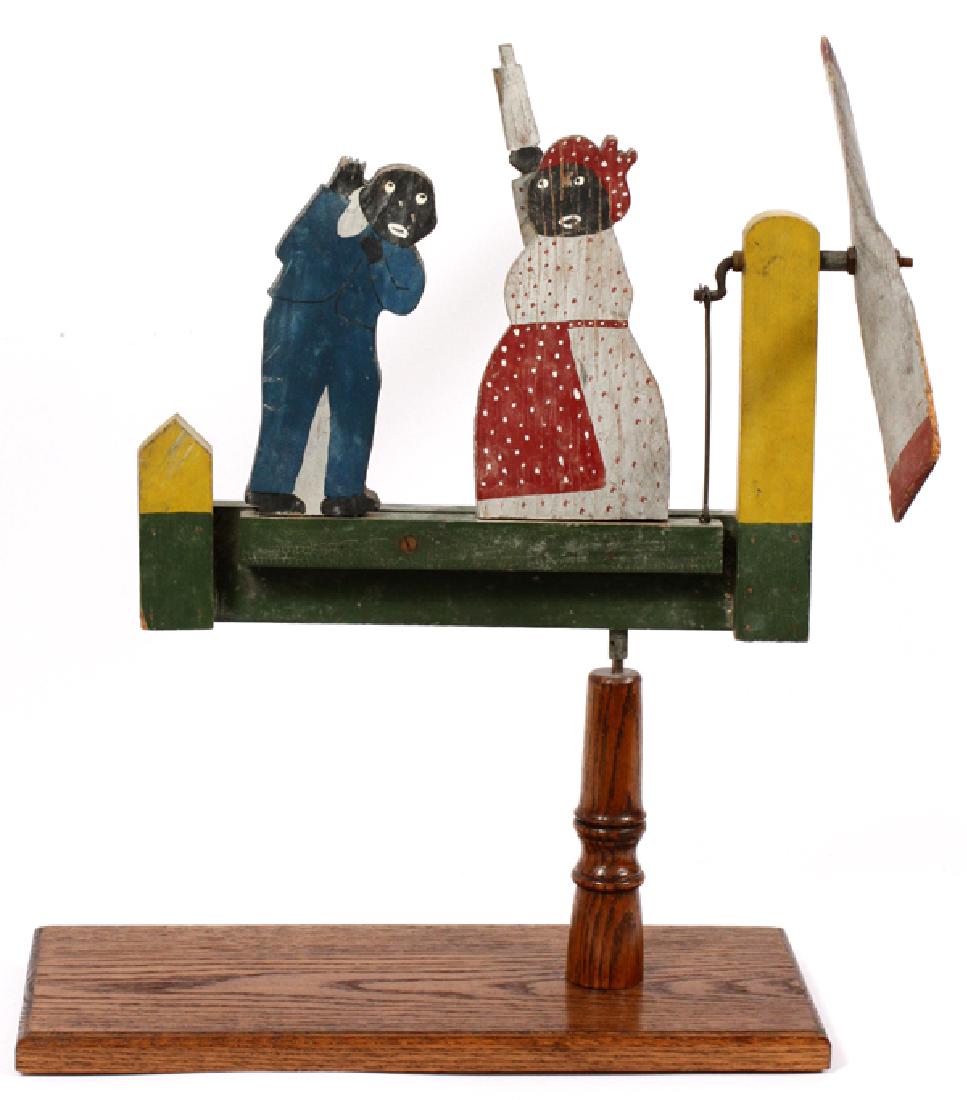 BLACK AMERICANA WOOD WHIRLIGIG CIRCA 1900-1920: BLACK AMERICANA WOOD WHIRLIGIG, CIRCA 1900-1920, H 24", L 13.75":Depicting a woman scolding a man.