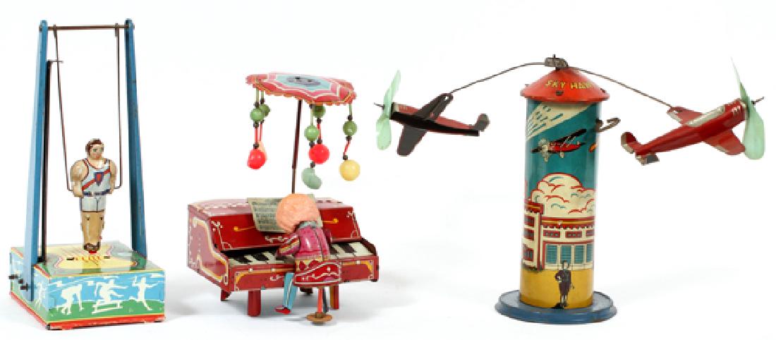 TIN LITHO FIGURAL TOYS THREE: TIN LITHO FIGURAL TOYS, THREE, H 7"-8 3/4":Includes the Marx tin litho 'Sky Hawk' airplane toy, a piano, and figural gymnast on rings toy. Length of airplane toy: 19 1/2".