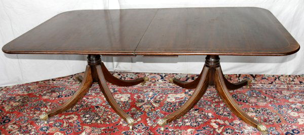 DUNCAN PHYFE STYLE, MAHOGANY DINING TABLE: DUNCAN PHYFE STYLE, MAHOGANY DINING TABLE WITH THREE LEAVES, C. 1920, W 44", L 78":Raised on two pedestal bases, with four out-swinging legs, footed with brass claw mounts on casters.