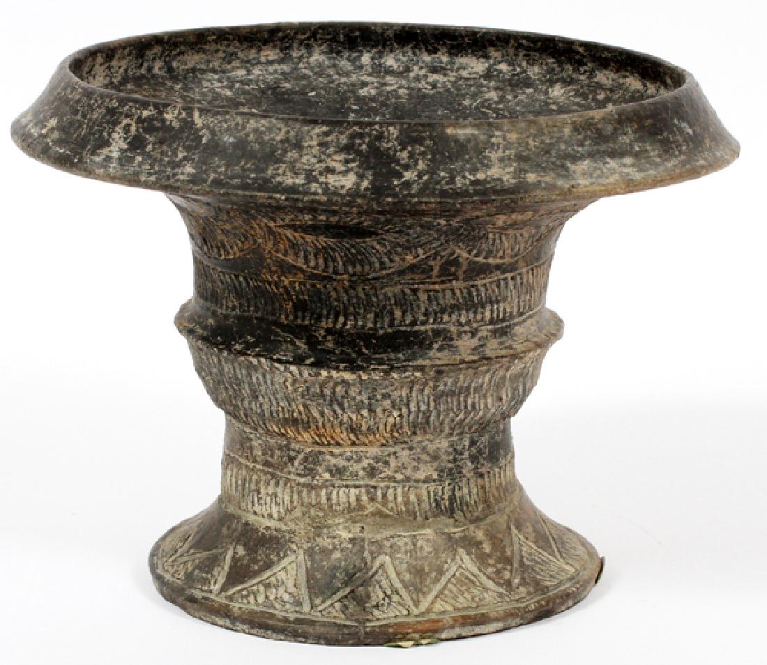 BAN CHIENG STYLE BLACKWARE FIRED CLAY VESSEL: BAN CHIENG STYLE, BLACKWARE FIRED CLAY VESSEL, H 6 1/4", DIA 8 1/2":Having a flared rim contoured body and flared round base. Intertwining around the sides. Provenance: Jane Baum Interiors, New York, 