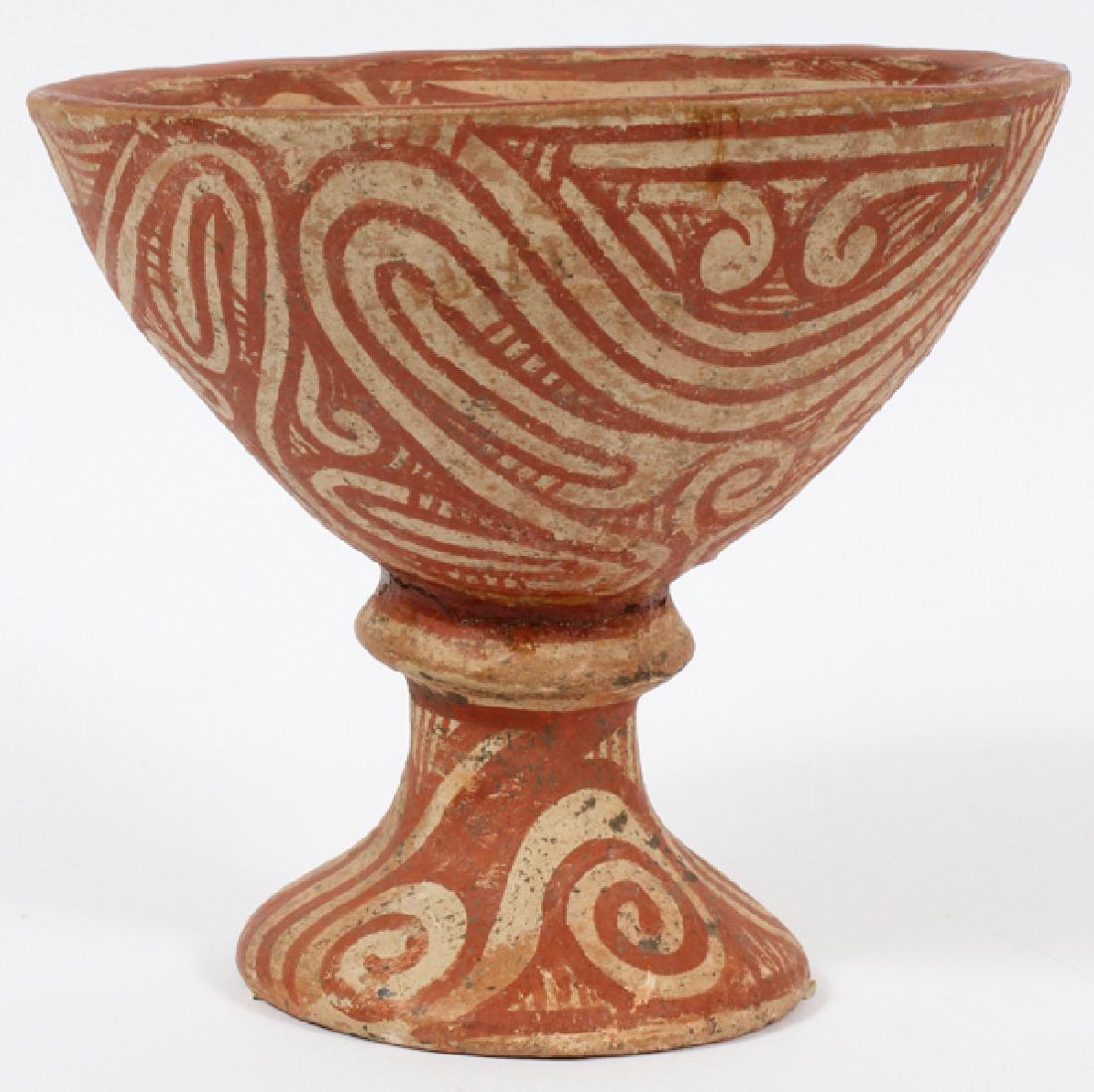 BAN CHIENG STYLE RED-PAINTED FIRED CLAY VESSEL: BAN CHIENG STYLE RED-PAINTED FIRED CLAY VESSEL, H 6.5":Having a stripe design throughout the piece, flared pedestal base. Provenance: Jane Baum Interiors, New York, March 3, 1979