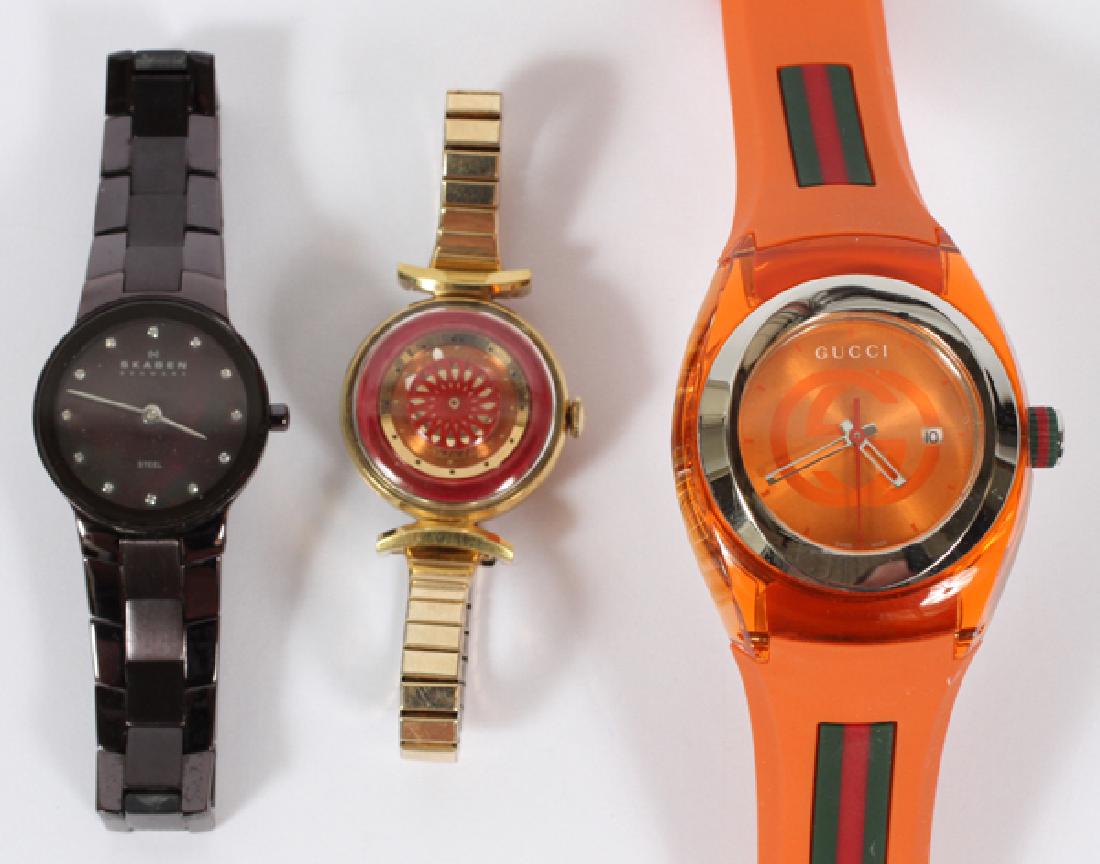 NOVELTY WRIST WATCHES 3; SKAGEN GUCCI BOREL: NOVELTY WRIST WATCHES, 3; SKAGEN, GUCCI, BOREL:Includes: Skagen, Denmark black plastic wrist watch; Ernest Borel, lady's wrist watch with metal base; Gucci novelty wrist watch #1373, orange plastic ba