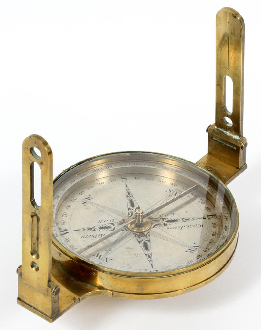 W & S JONES LONDON BRASS CIRCUMFERENTOR: W & S JONES, LONDON, BRASS CIRCUMFERENTOR (SURVEYOR'S COMPASS), H 3", DIA 9":The silvered compass rose engraved with compass points, four quadrants and circle of degrees, the alidade with open sights.