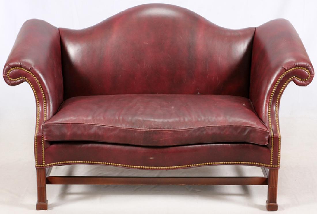 HANCOCK & MOORE LEATHER UPHOLSTERED LOVESEAT: HANCOCK & MOORE LEATHER UPHOLSTERED LOVESEAT, H 38", W 63", D 34":Having a camel back shaped backrest, scrolling padded arms. A removable seat cushion, the whole raised on carved block legs. Brass uph