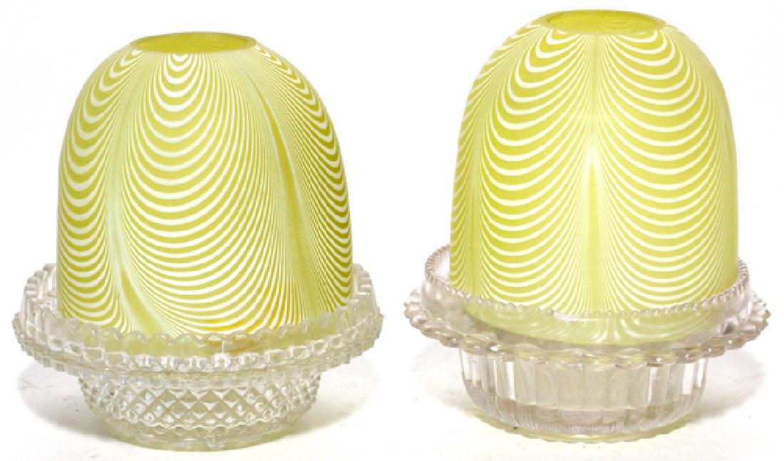 VICTORIAN YELLOW NAILSEA FAIRY LAMPS LATE 19TH C.: VICTORIAN YELLOW NAILSEA FAIRY LAMPS, LATE 19TH C., PAIR, H 5 1/4", DIA 4 1/4":A pair of Nailsea-type domes with yellow ground, each raised on a clear lamp cup. From the Estate of Dr. Henry and Grace 
