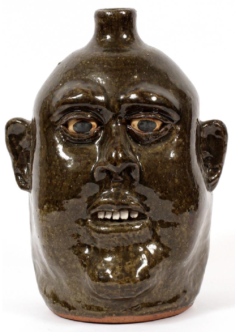 LANIER MEADERS STONEWARE FACE JUG: LANIER MEADERS STONEWARE FACE JUG, H 11", W 8":Incised signature to the underside (see additional photo). Measures approximately H.11" x 8" x 7".