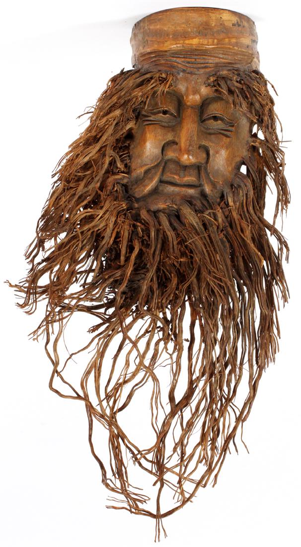 INDONESIAN DECORATIVE CARVED HARDWOOD FACE: INDONESIAN DECORATIVE CARVED HARDWOOD FACE, H 15'', W 8''A DECORATIVE CARVED HARDWOOD FACE, HAVING PLANT FIBER HAIR AND DEEPLY CARVED FEATURES. THE BACK INDICATES THAT IT IS MEANT TO BE HUNG FOR DECOR