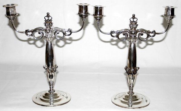 GEORG JENSEN .830 SILVER CANDELABRA, C.1920: GEORG JENSEN .830 SILVER CANDELABRA, PROBABLY JOHAN ROHDE, C. 1920, PAIR, H 12 1/2", W 10 3/4":Each two-light candelabrum centered by a crown-form finial, the whole adorned with scroll, lappet and bea