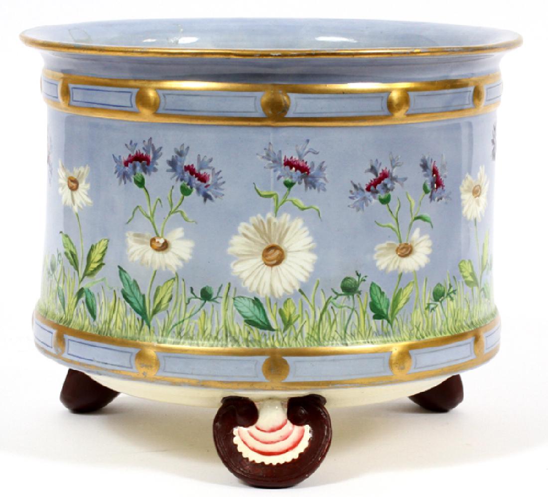 MINTON PORCELAIN PLANTER, H 8 1/2", W 10": MINTON, PORCELAIN PLANTER, H 8 1/2", W 10" HAVING A CYLINDRICAL SHAPE WITH A FLARED RIM, BLUE GROUND, WITH FLOWERS AND FIRED GOLD ACCENTS. THREE SHELL FORM FEET.